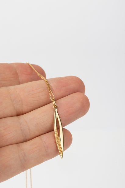 Yellow gold forcat chain holding a navette...