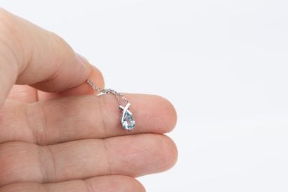 White gold forcat chain holding a cross pendant...