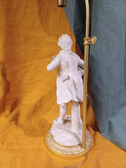 Pied de lampe en biscuit figurant un marchand...