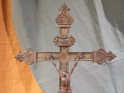 Grand crucifix en métal doré, reposant sur...