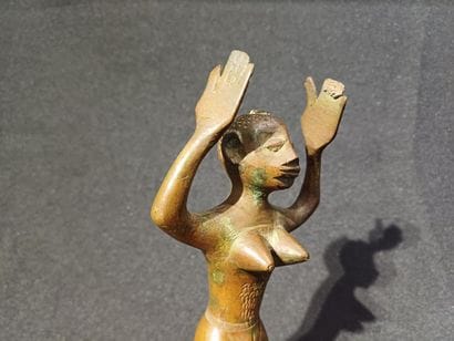 Kneeling figure on a pedestal, raising his...