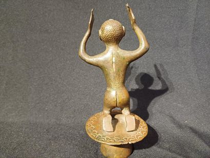 Kneeling figure on a pedestal, raising his...