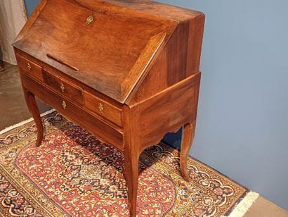 Walnut sloping desk opening to a flap revealing...