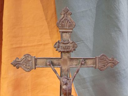 Grand crucifix en métal doré, reposant sur...