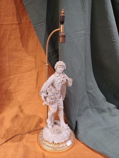 Pied de lampe en biscuit figurant un marchand...