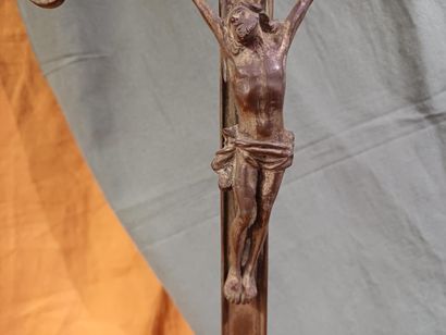 Grand crucifix en métal doré, reposant sur...
