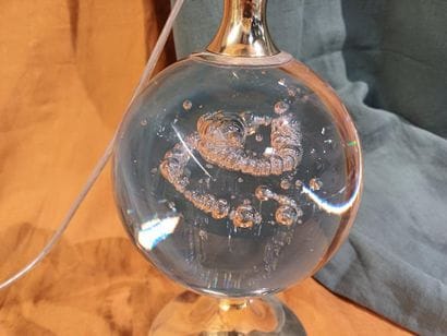 Brass lamp base adorned with a bubble glass...