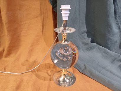 Brass lamp base adorned with a bubble glass...