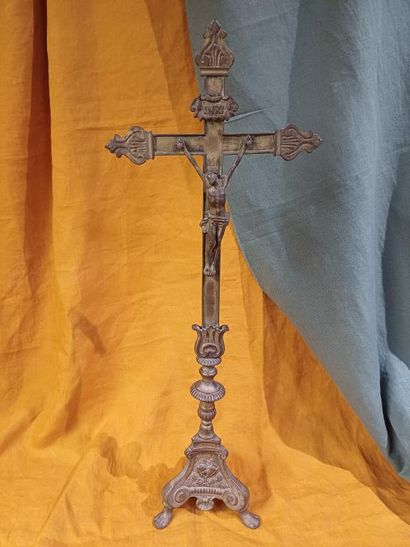 Grand crucifix en métal doré, reposant sur...