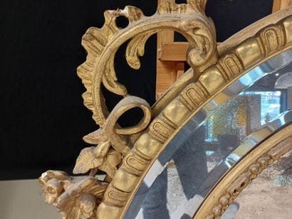 Oval wood and gilded stucco mirror with shell...