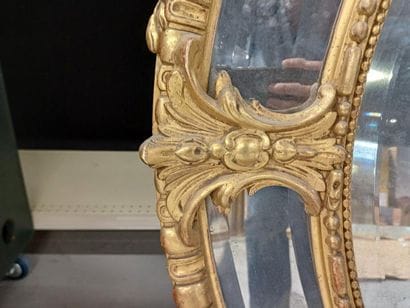 Oval wood and gilded stucco mirror with shell...