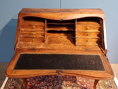 Walnut sloping desk opening to a flap revealing...