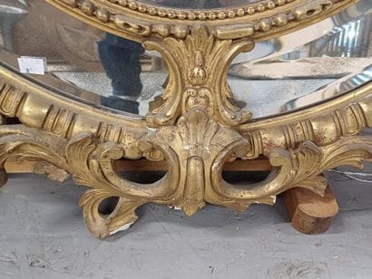 Oval wood and gilded stucco mirror with shell...