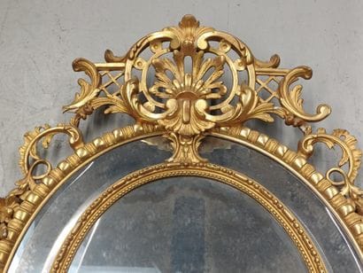 Oval wood and gilded stucco mirror with shell...
