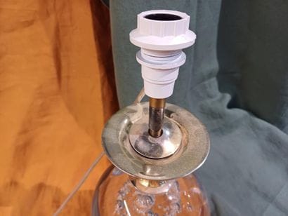 Brass lamp base adorned with a bubble glass...