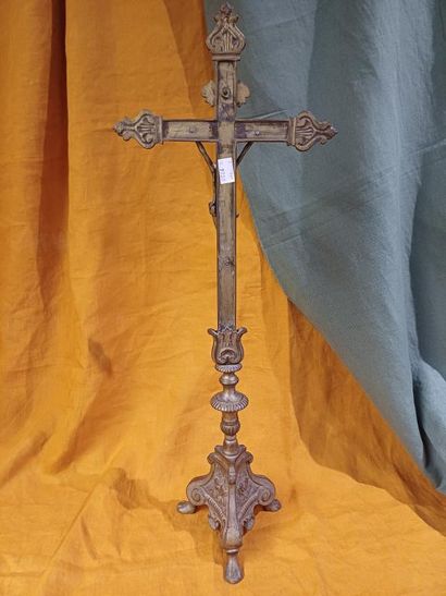 Grand crucifix en métal doré, reposant sur...