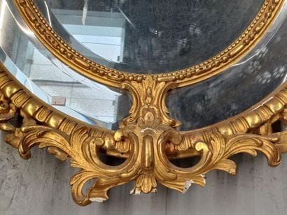Oval wood and gilded stucco mirror with shell...