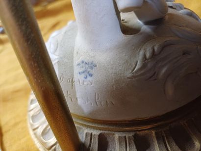 Pied de lampe en biscuit figurant un marchand...