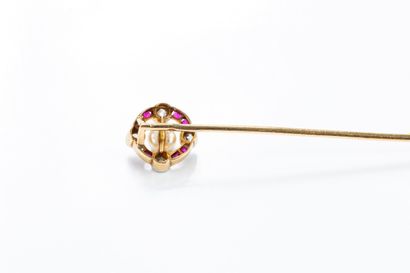 Gold tie pin featuring a circular motif centered...