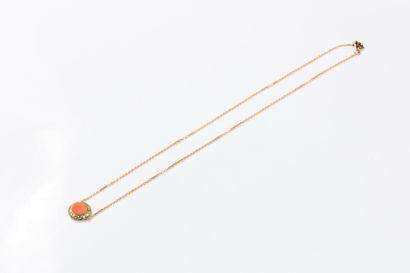 Yellow gold forçat chain centered on a coral...