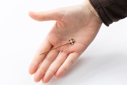 Gold tie pin featuring a circular motif centered...