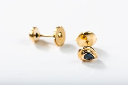 Pair of pear-shaped gold earrings centered...