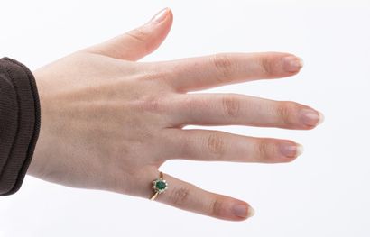 Yellow gold daisy ring centered on an emerald...