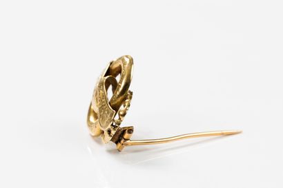 Yellow gold brooch featuring scrolling ribbons...