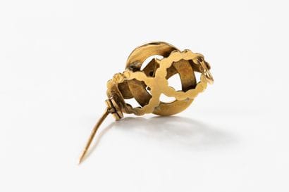 Yellow gold brooch featuring scrolling ribbons...