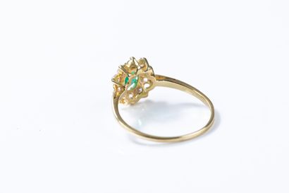 Yellow gold daisy ring centered on an emerald...