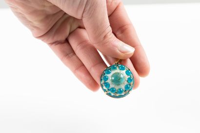 Yellow gold pendant adorned with a blue and...
