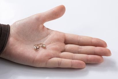 Pair of gold sleeper earrings, each punctuated...