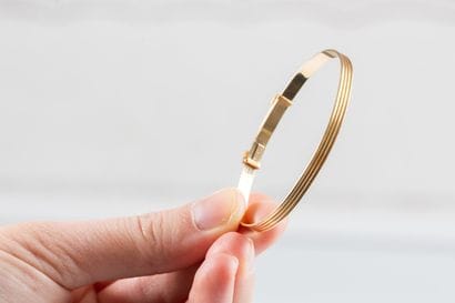 Yellow gold, sliding, ribbon-shaped, gadrooned...