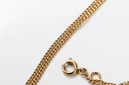 Gold chain with a gold medal depicting Christ...