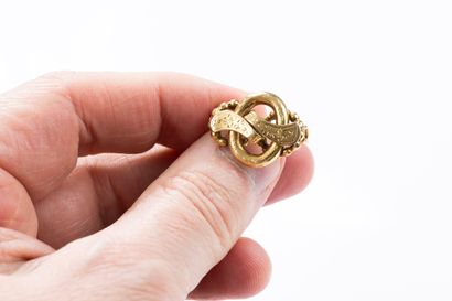 Yellow gold brooch featuring scrolling ribbons...