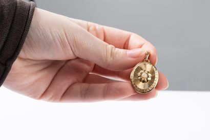 Yellow gold oval pendant with chased and...