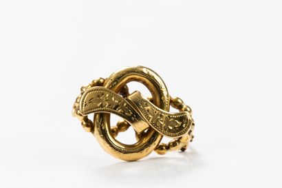 Yellow gold brooch featuring scrolling ribbons...