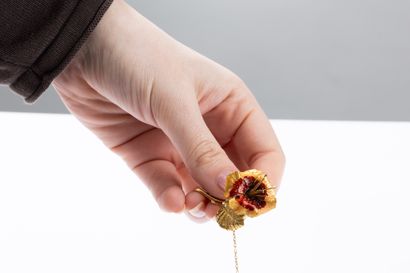 Yellow gold brooch featuring a flower with...