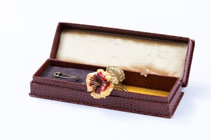 Yellow gold brooch featuring a flower with...