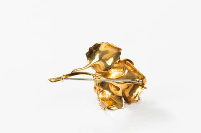 Yellow gold brooch featuring a flower with...