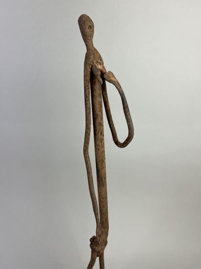 Standing female figure. She is holding her...
