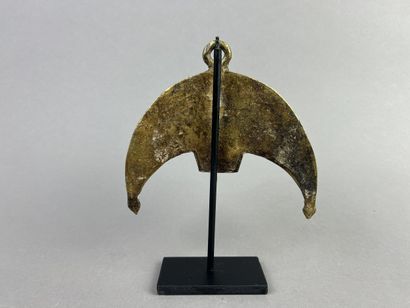 Crescent-shaped pendant featuring a figure...