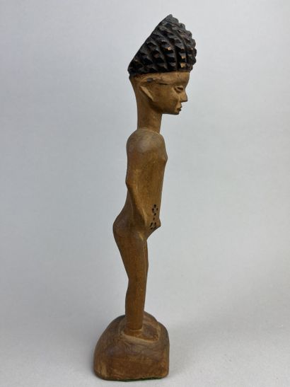 Statuette depicted standing on a round base,...