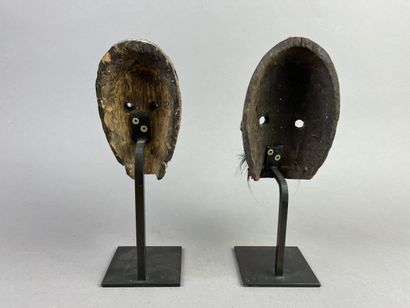 Two diminutive masks. Wood with earthy patina,...