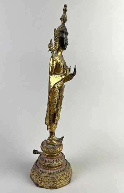 Buddha depicted standing on a pedestal, hands...