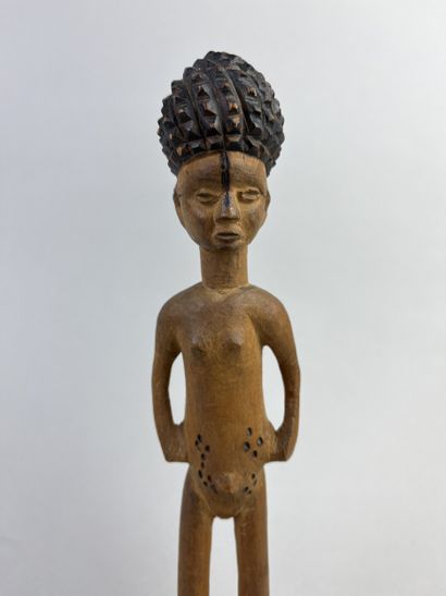 Statuette depicted standing on a round base,...