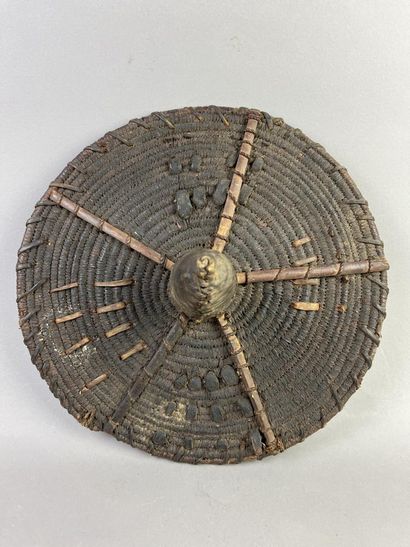Round wickerwork dance shield with leather-covered...