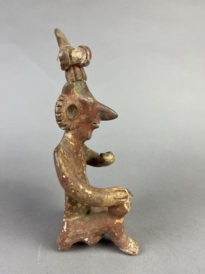 Seated figure, one knee on the ground, holding...