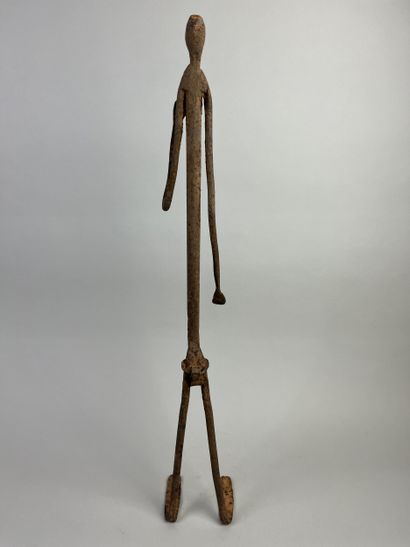 Standing female figure. She is holding her...