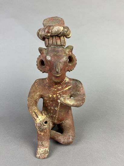 Seated figure, one knee on the ground, holding...